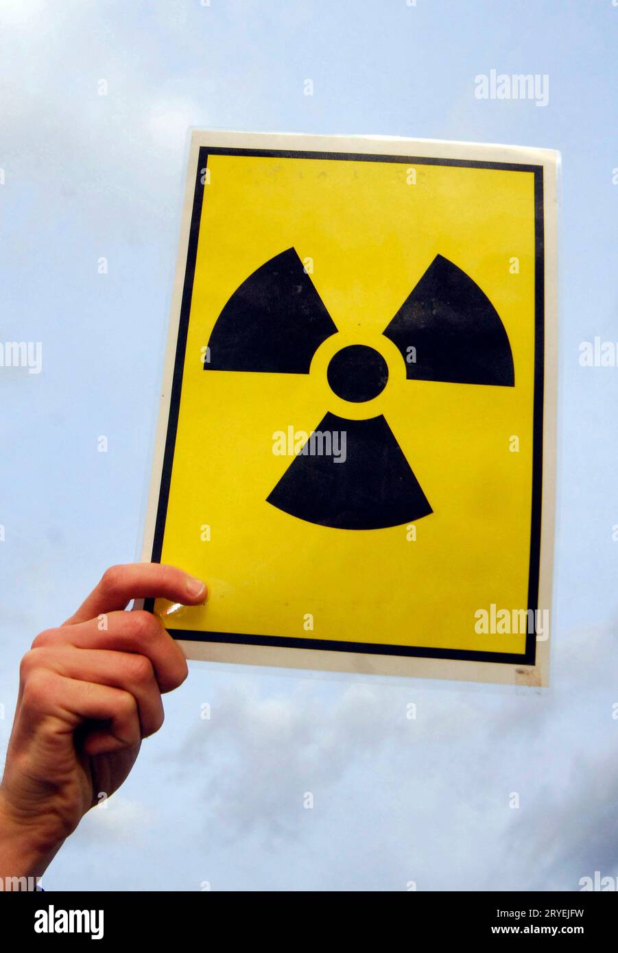 Hand holding warning sign for radioactive material Stock Photo