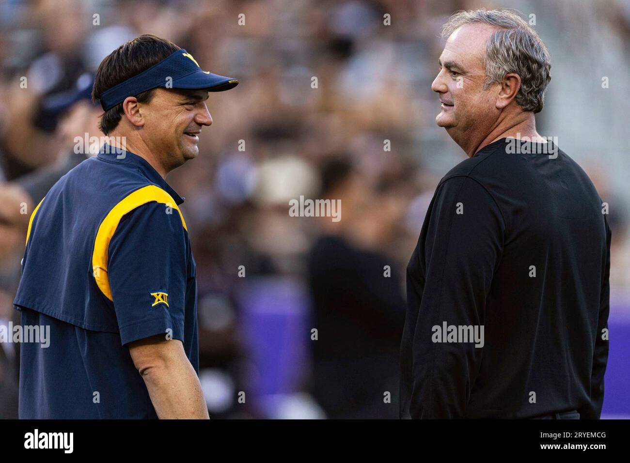 West Virginia coach Neal Brown, left, talks with TCU coach Sonny Dykes ...