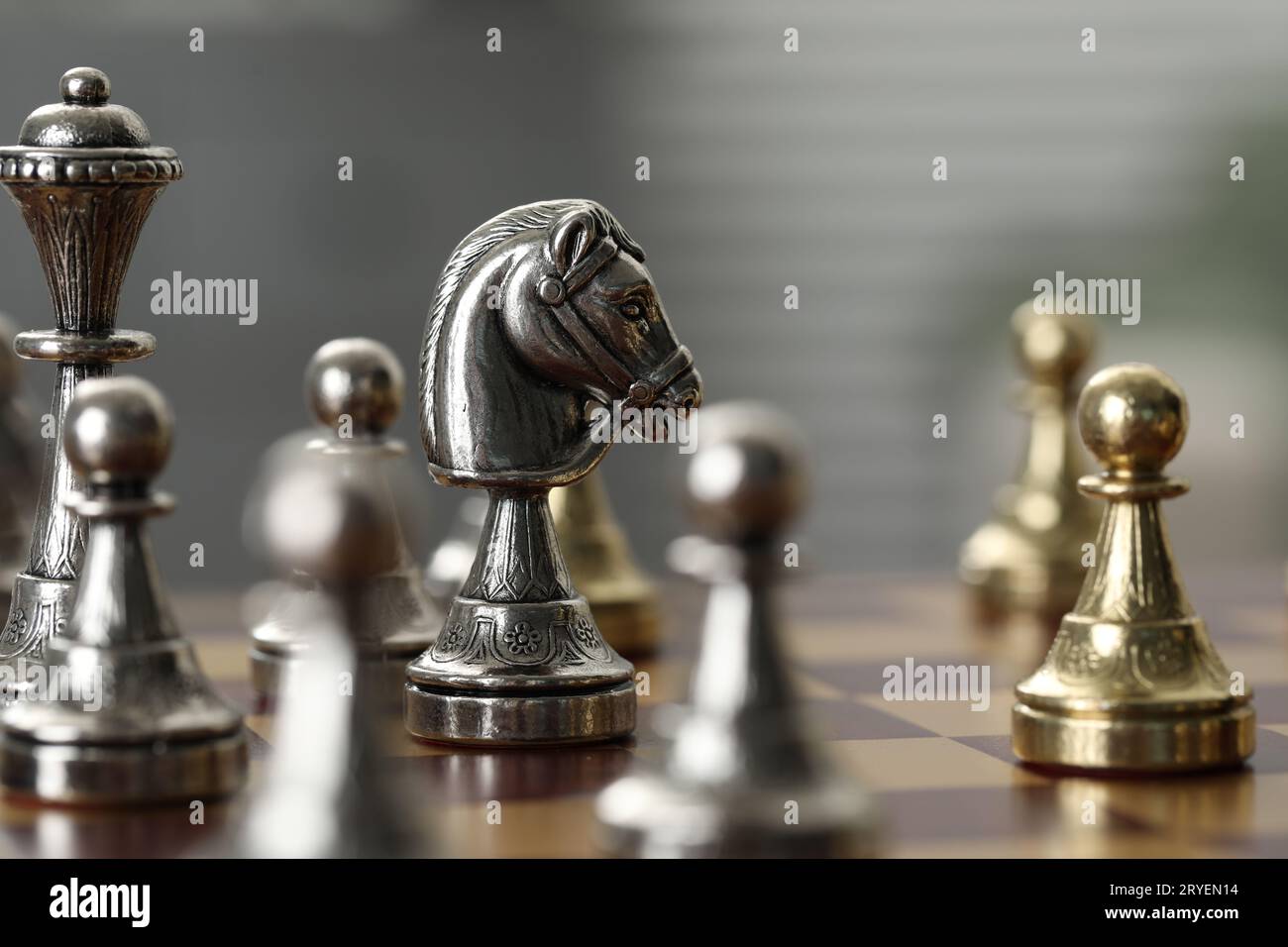 Silver knight and other chess pieces on game board, closeup Stock Photo