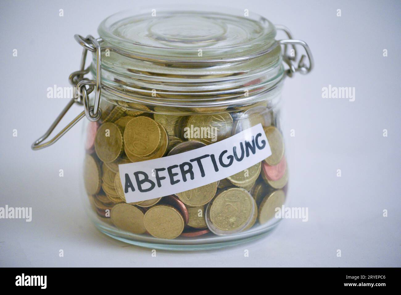 Jar with coins saying 'Abfertigung' (financial compensation) Stock Photo