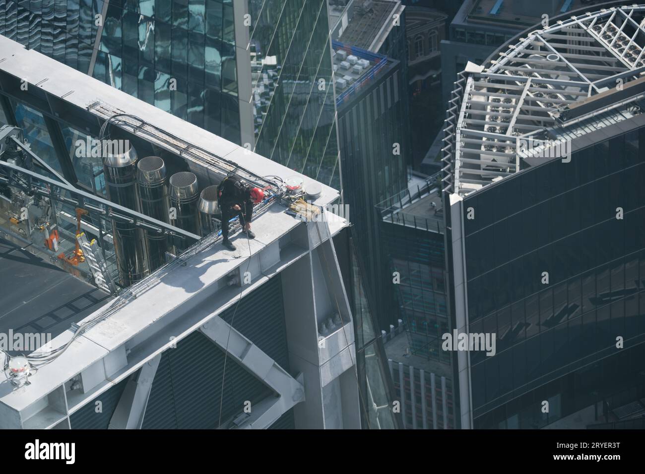 A climber on top of a skyscraper prepares to clean it Stock Photo
