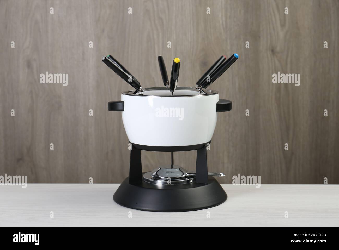 https://c8.alamy.com/comp/2RYET8B/fondue-set-on-white-wooden-table-kitchen-equipment-2RYET8B.jpg