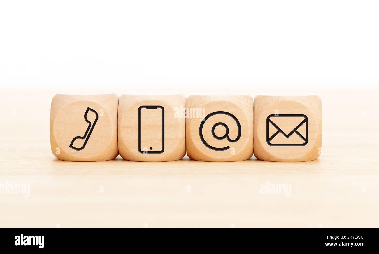 Contact us icons in wooden blocks on wooden desk. Copy space Stock Photo