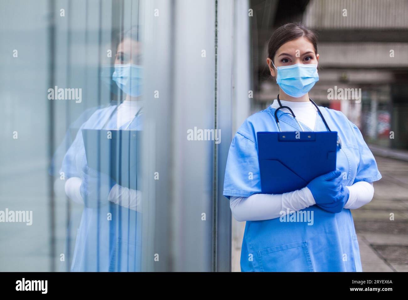 Young female NHS UK EMS doctor in front of healthcare ICU facility Stock Photo
