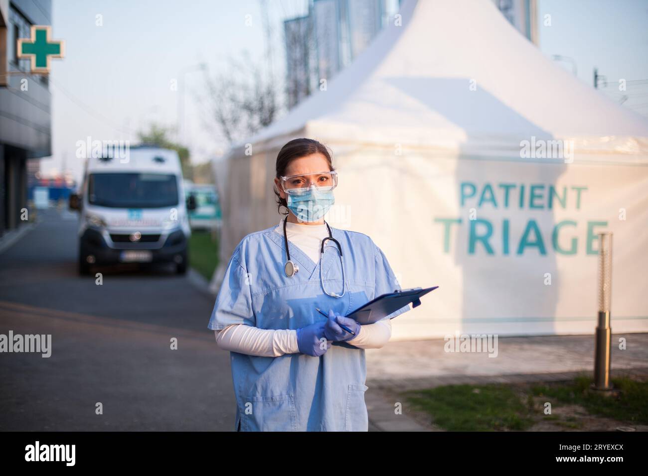 Portrait of serious female key front line worker in blue PPE uniform ...