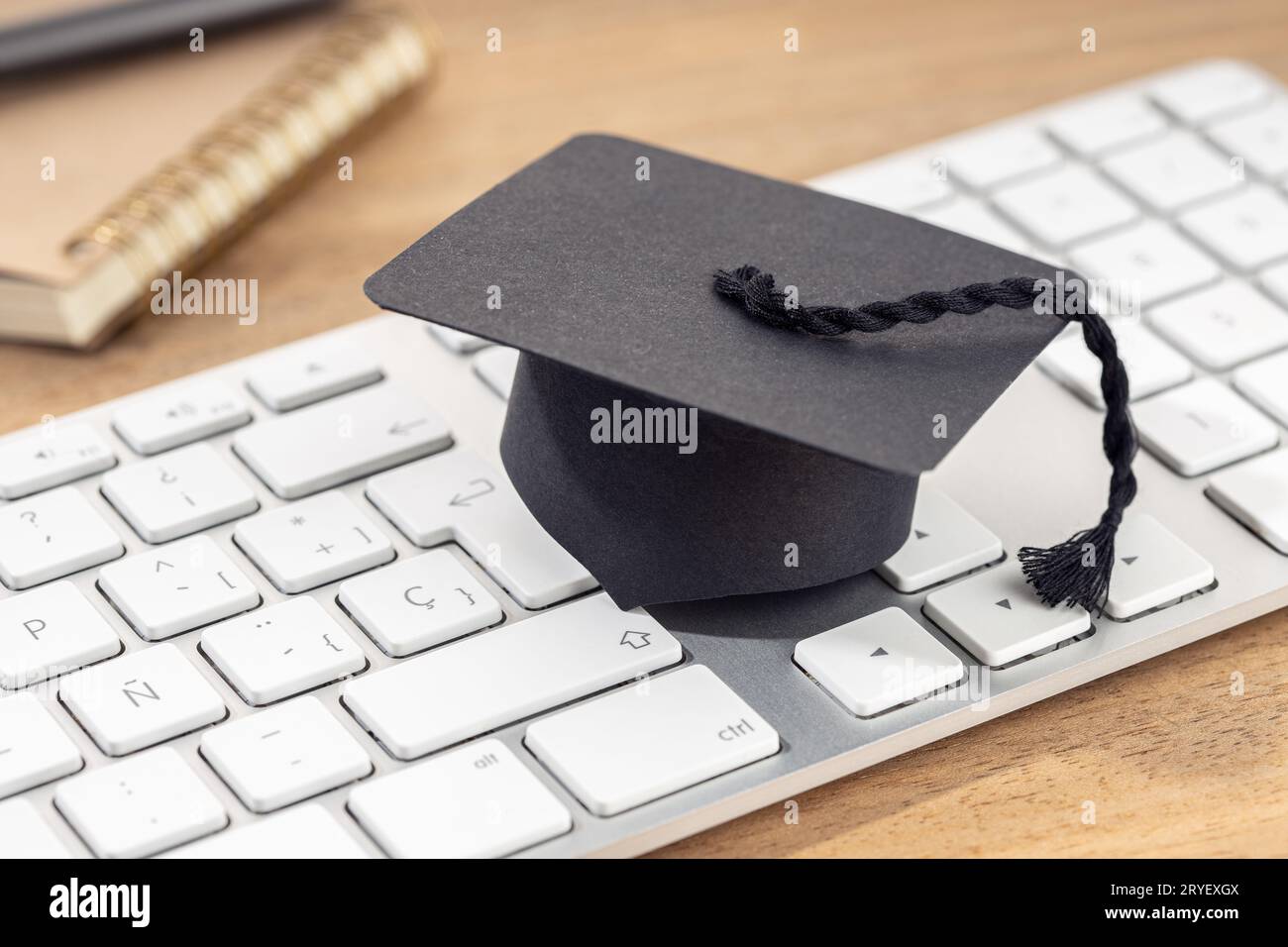 E-Learning or home study concept. Graduation cap on computer keyboard Stock Photo