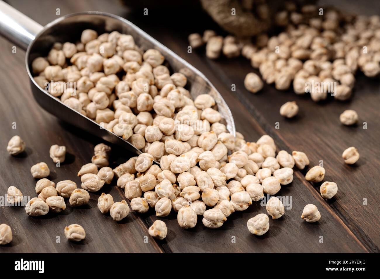 Uncooked Chickpeas on scoop on rustic wooden table. Rustic still life Stock Photo