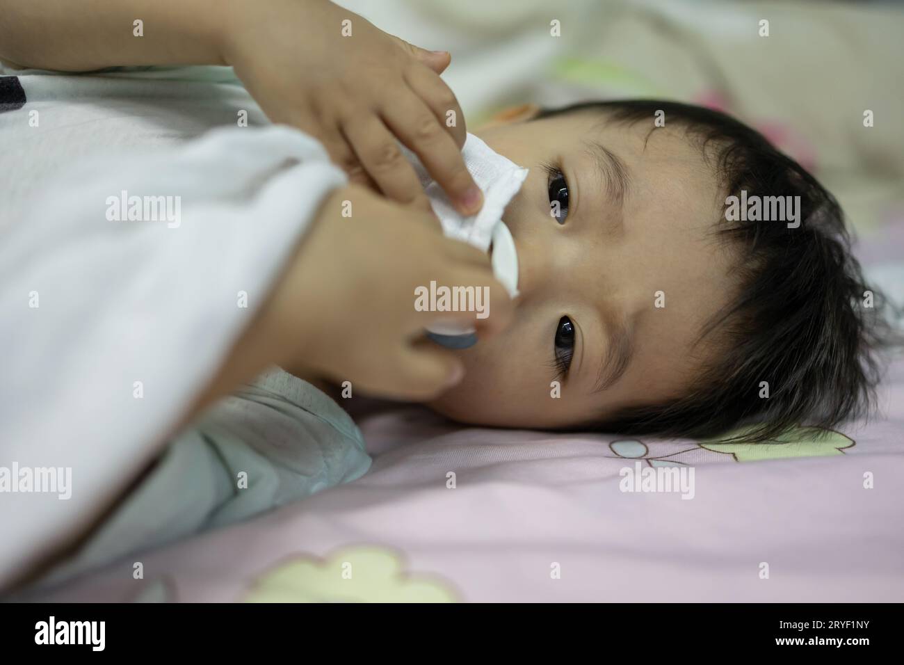 Portrait image of 1-2 years old child relaxing and chill while lying on bed Stock Photo