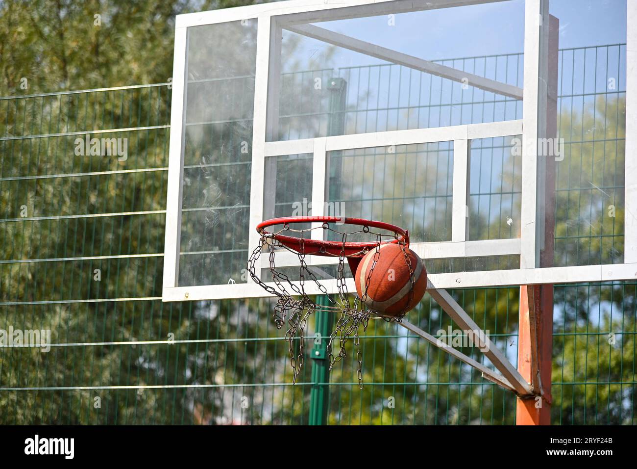 Shooting orange basketball ball into the basket Stock Photo