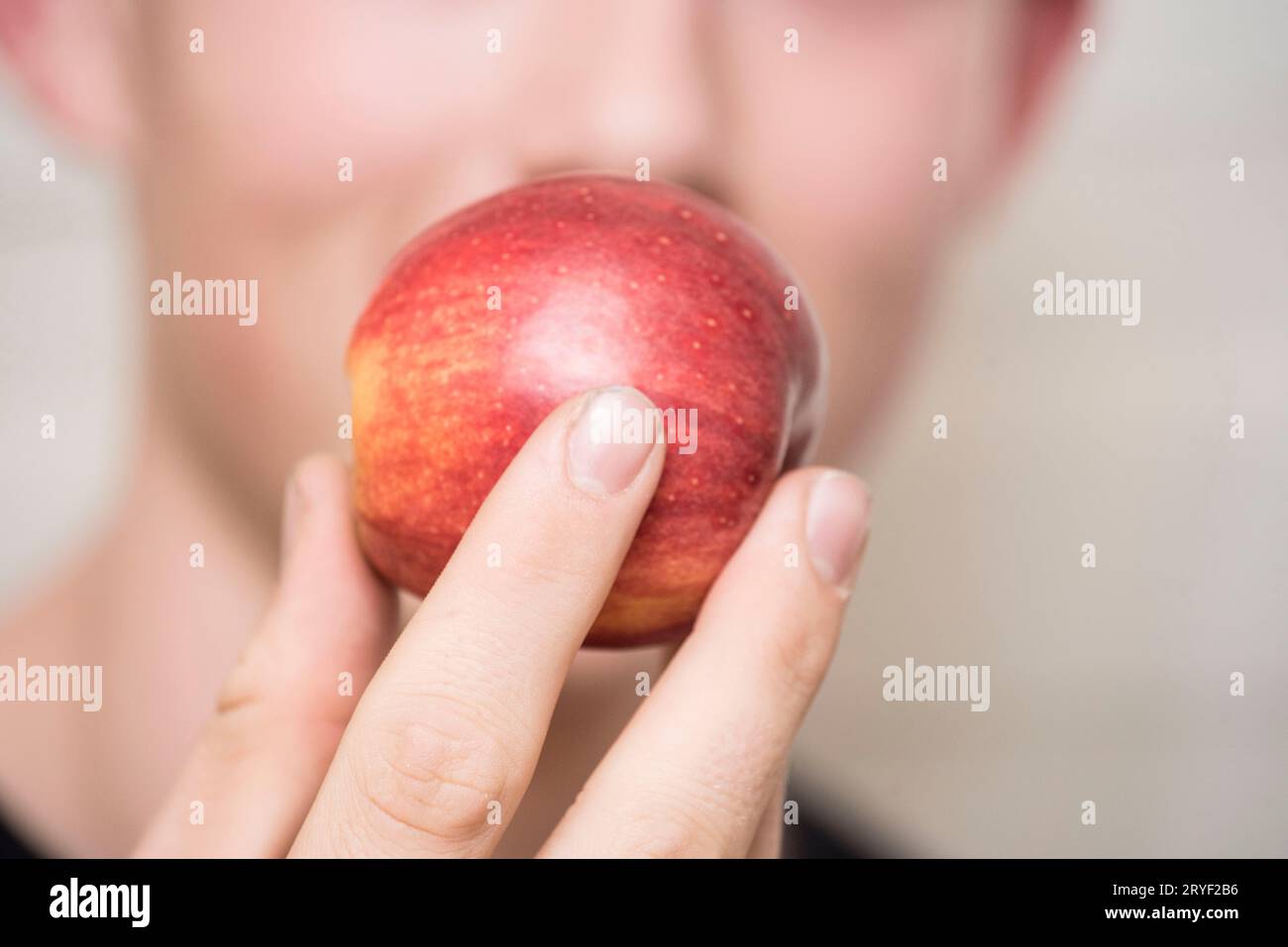 Consumer with apple in hand Stock Photo
