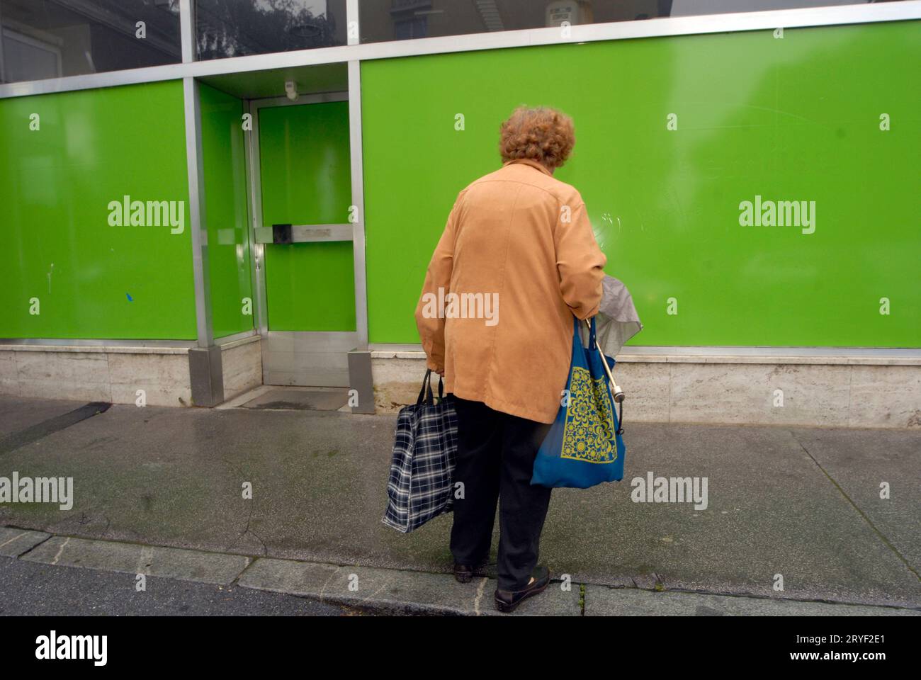 Lonely old woman taking home her groceries Stock Photo