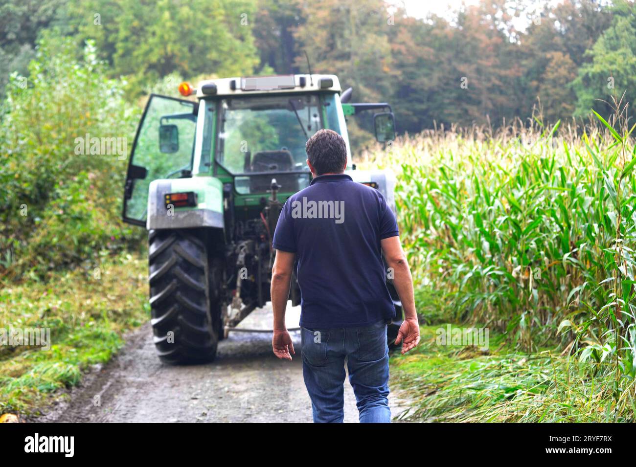 Farmer with tractor on the field Stock Photo - Alamy