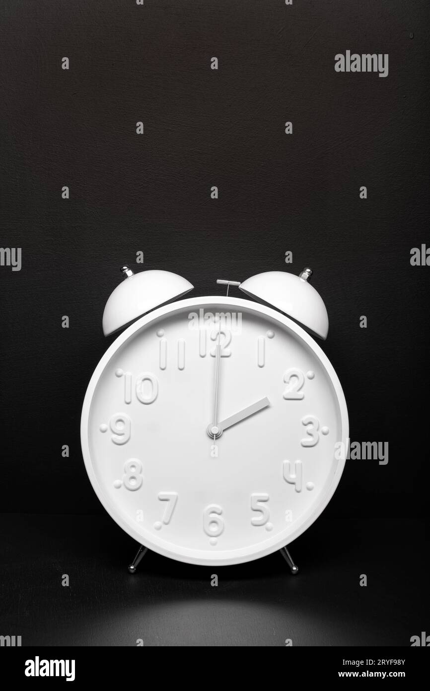 Daylight saving time concept. White Retro clock isolated on black background. Copy space Stock Photo