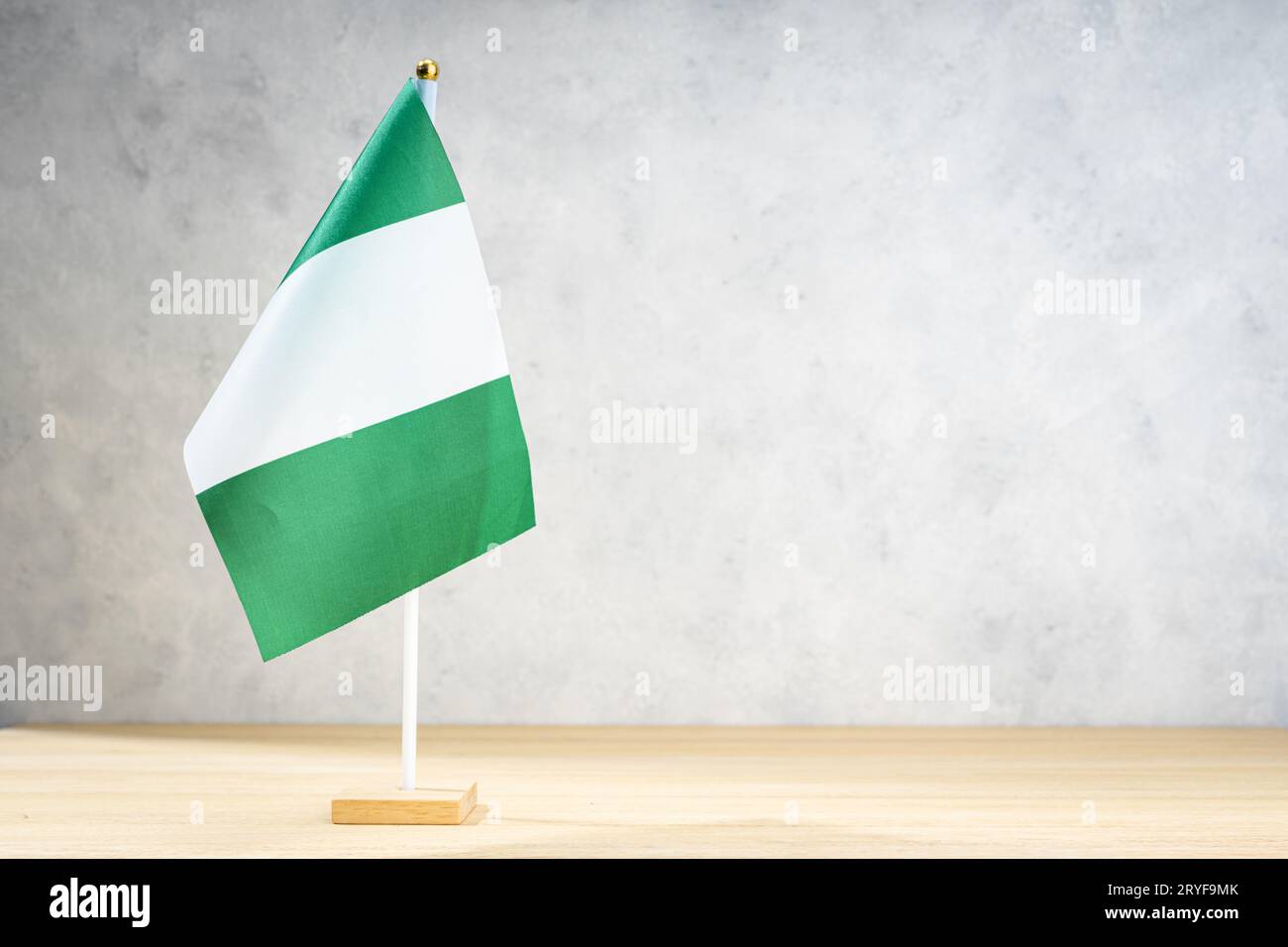 Nigeria table flag on white textured wall. Copy space for text, designs or drawings Stock Photo
