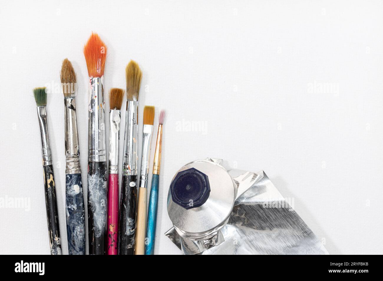 Artist paint brushes and paint cans of paint over bright watercolor  background Stock Photo