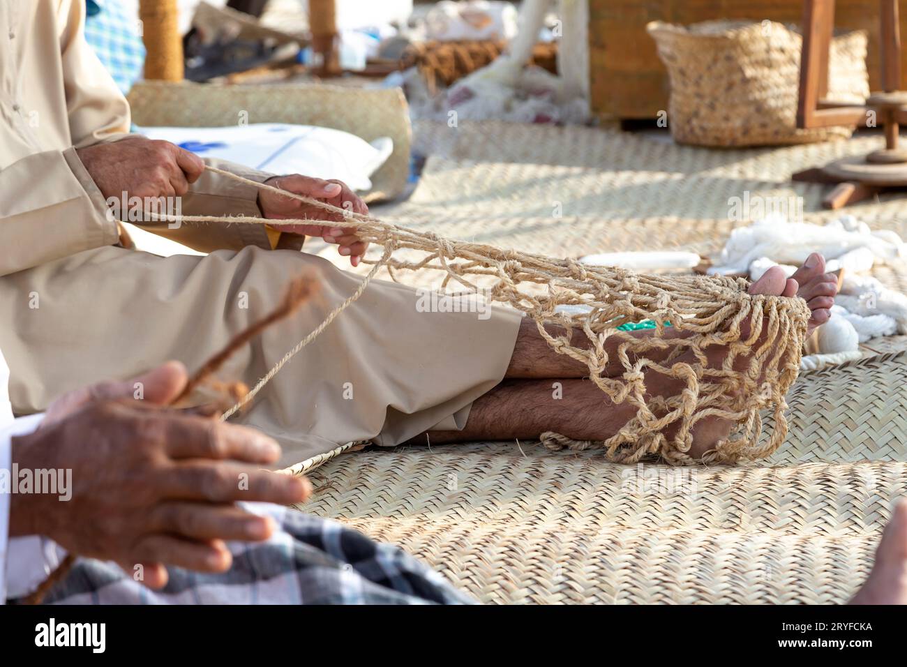 https://c8.alamy.com/comp/2RYFCKA/old-man-is-knitting-traditional-fishing-net-hands-in-frame-2RYFCKA.jpg