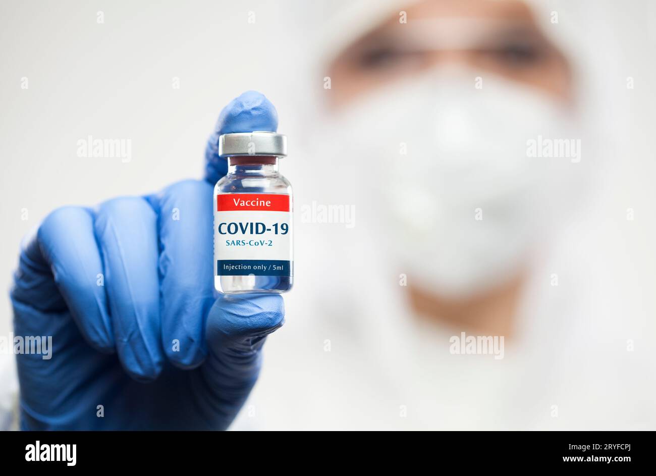 Medical NHS worker holding COVID-19 SARS-CoV-2 vaccine glass ampoule vial,wearing personal protectiv Stock Photo