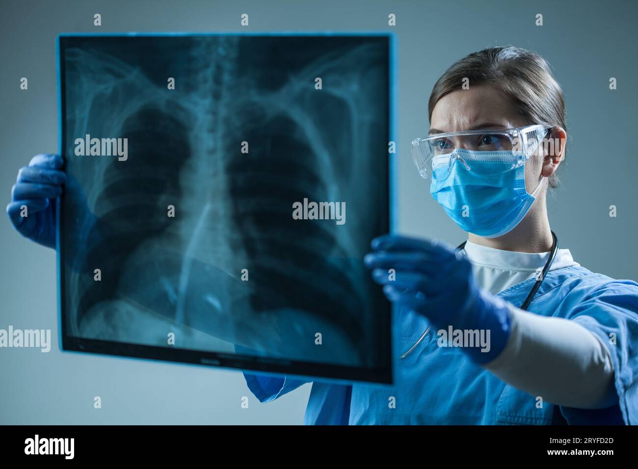 Female doctor looking at X-Ray radiography scan in patient room Stock Photo