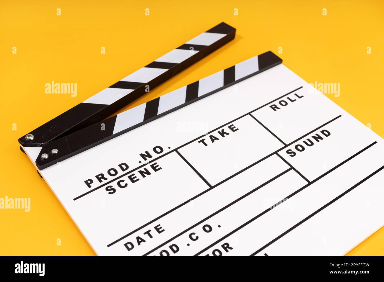 Movie clapper board and colored film reels detail on brown table