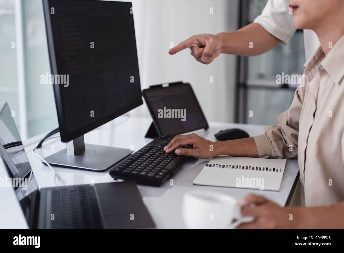 Two developer programmer discussing to checking code on monitor about ...