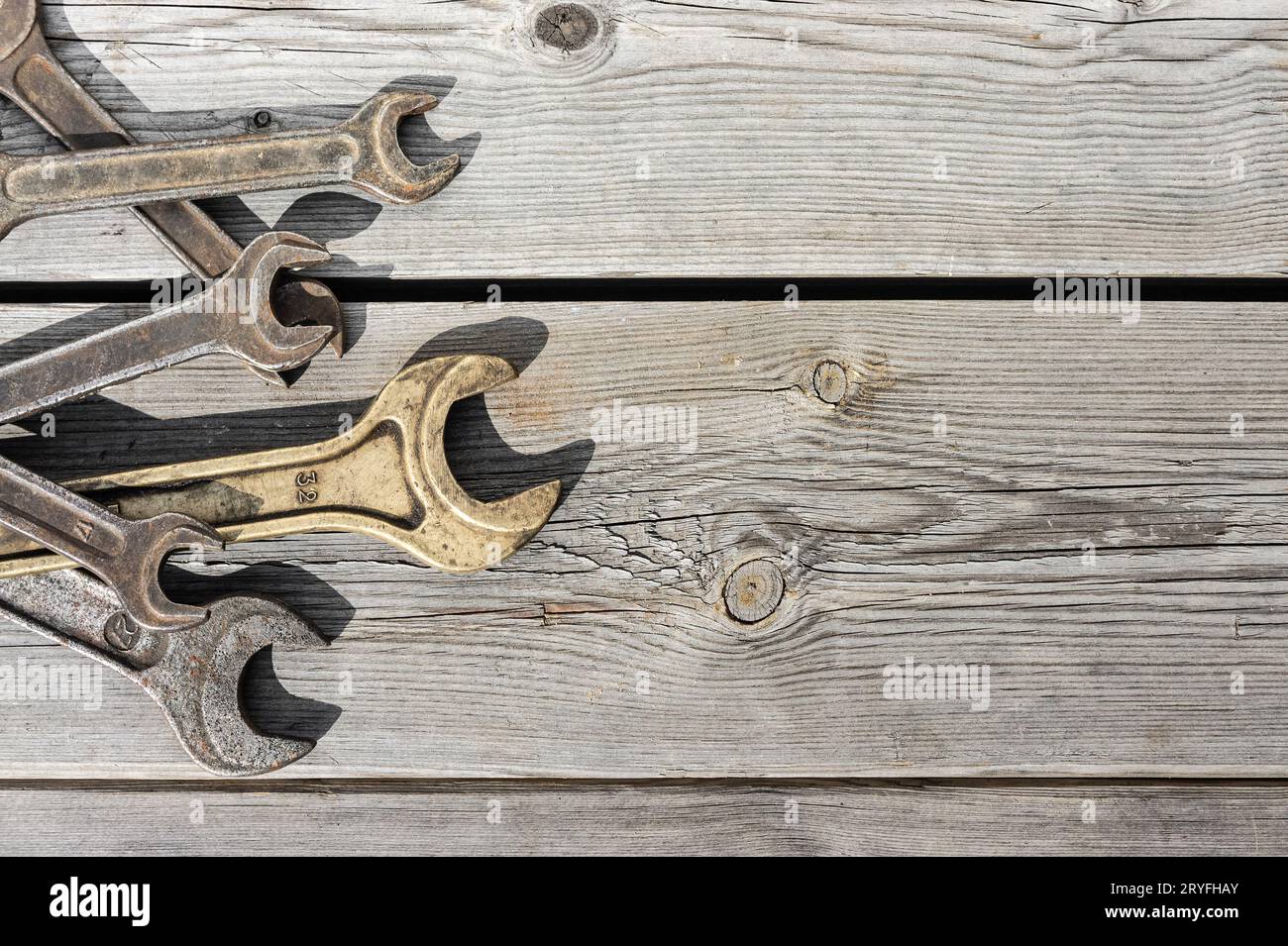 Old rusty wrenches on a wooden table Stock Photo