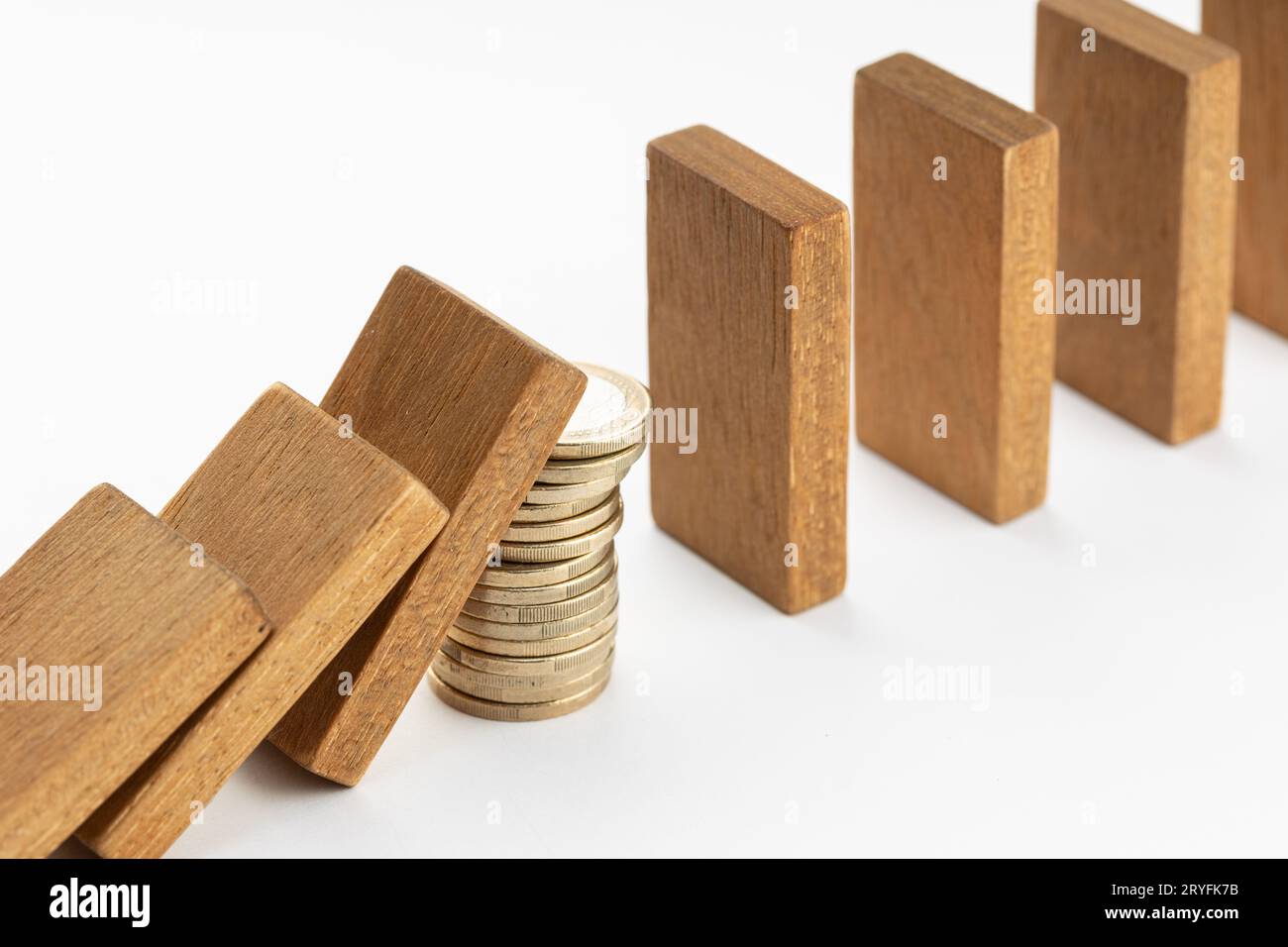 Pile of coins Stopping Falling wooden Dominoes effect. Money support or stimulus stop the financial crisis domino effect Stock Photo