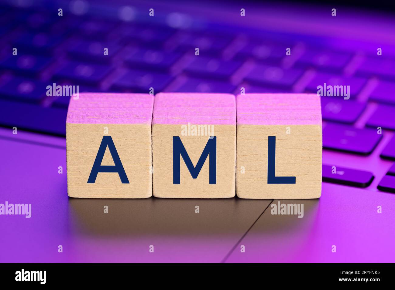 AML word on wooden blocks on laptop with colorful lights. Anti Money Laundering concept Stock Photo