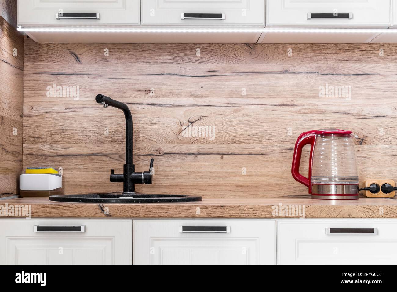 White kitchen set with kitchen utensils on the countertop. Stock Photo