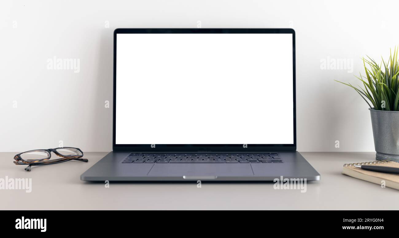 Modern laptop with blank white screen on minimalist desk. Mock up template Stock Photo