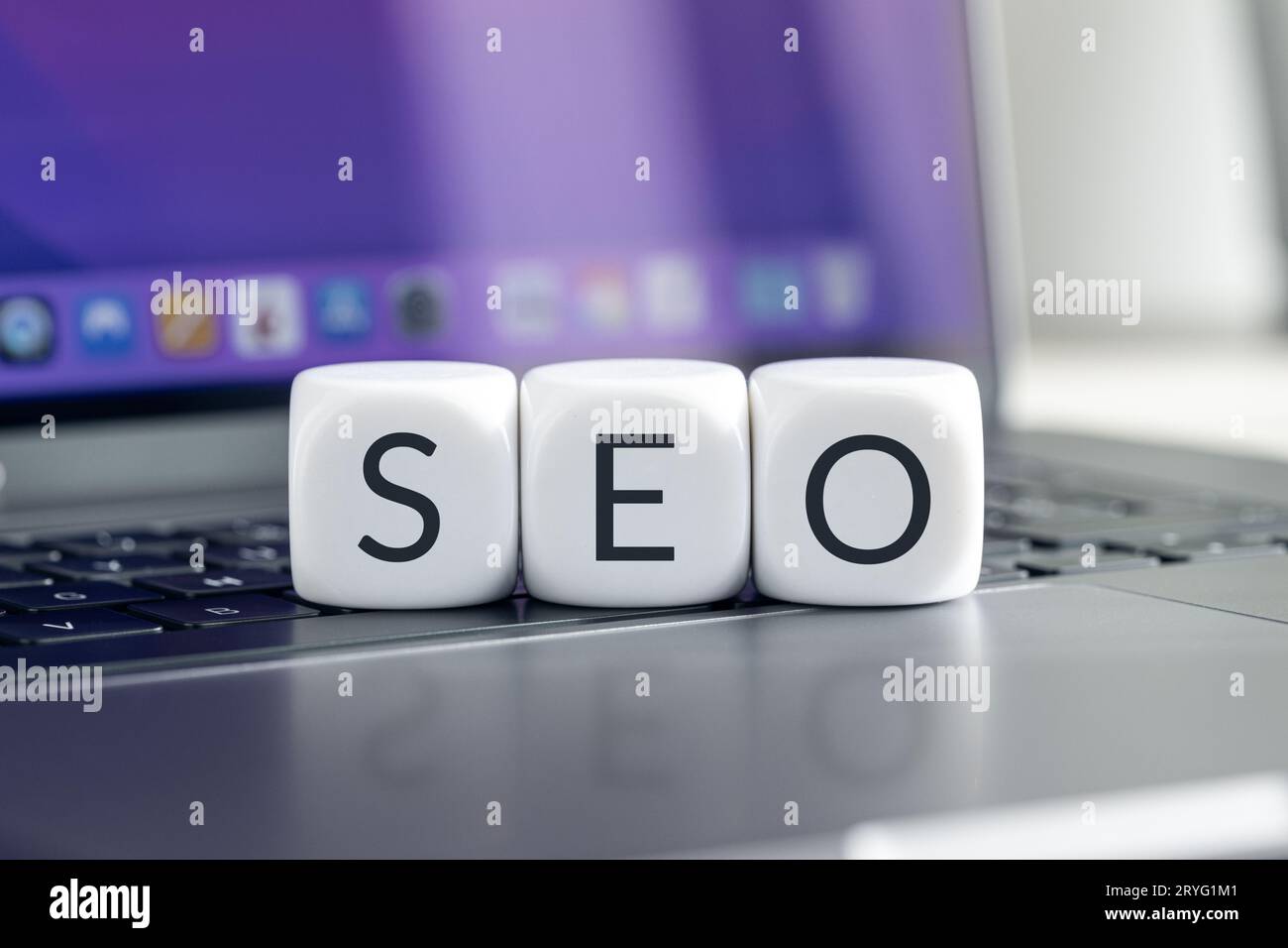 SEO or Search Engine optimization concept. Cube blocks with text on modern laptop Stock Photo
