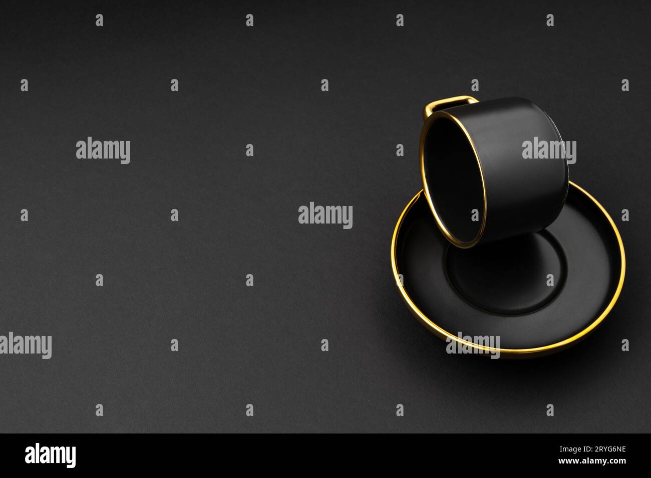 A set of black and golden ceramic plates and cup on a black background Stock Photo