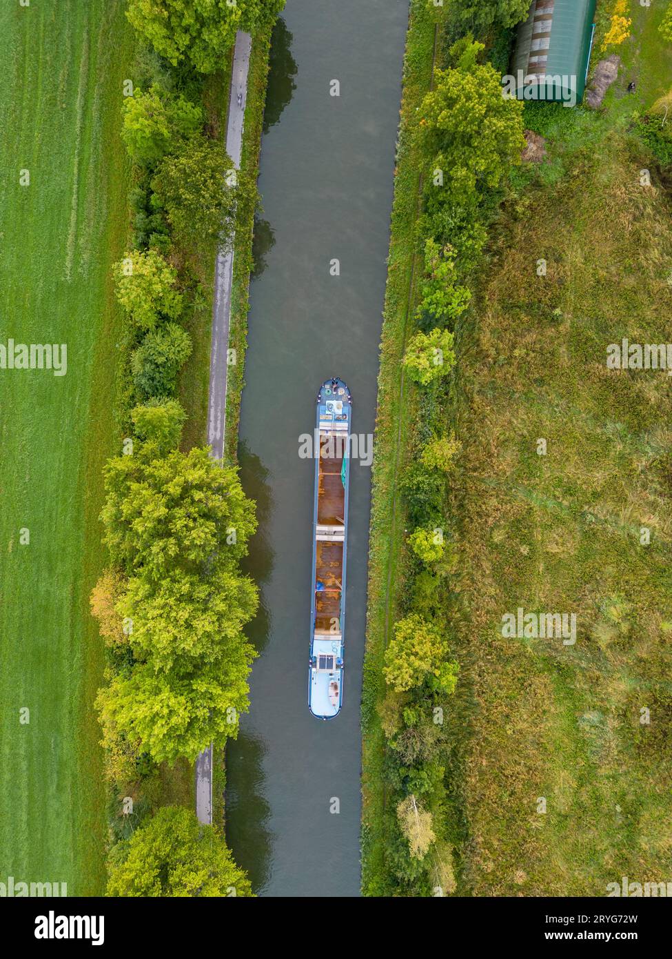 Aerial view of a canal with a cargo boat in Belgium. Canals with water for transport, agriculture. Fields and meadows. Landscape Stock Photo