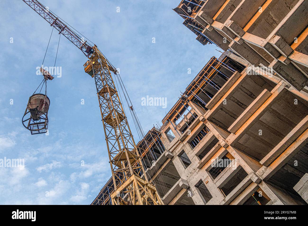 A low angle shot of a crane with equipment on a construction site with ...