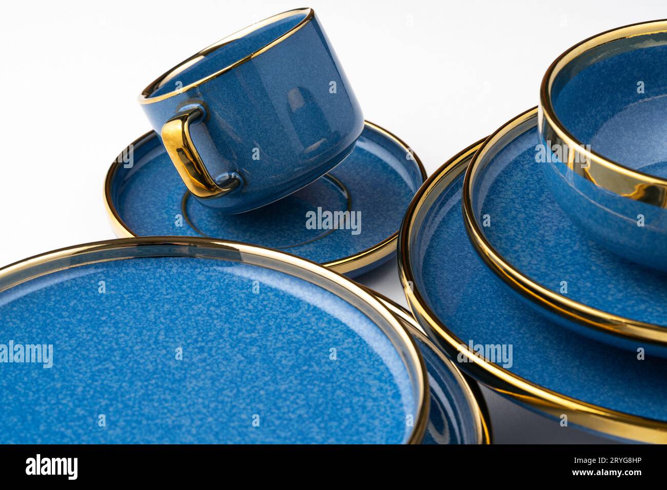 A set of blue ceramic plates and cup on a white background Stock Photo
