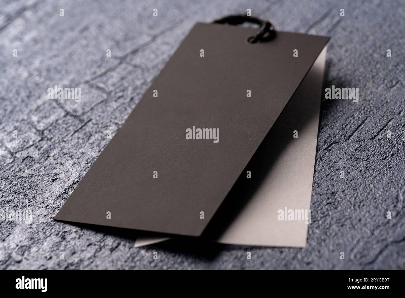 A closeup shot of a blank black clothing tag on a string for a price label on a cloth Stock Photo