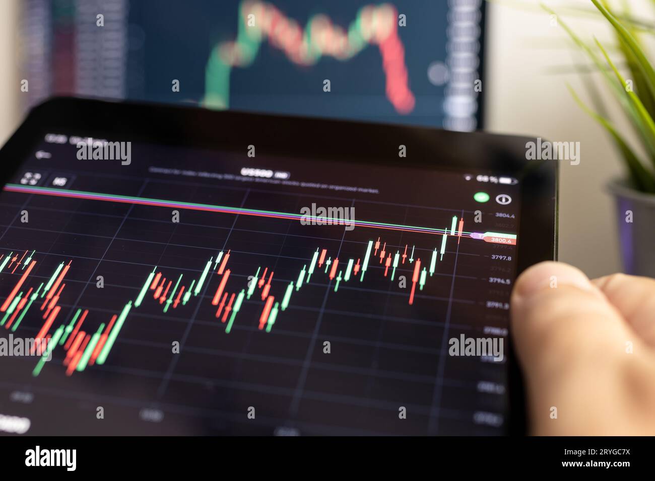 Hand holding digital tablet with stock market chart. Stock trading