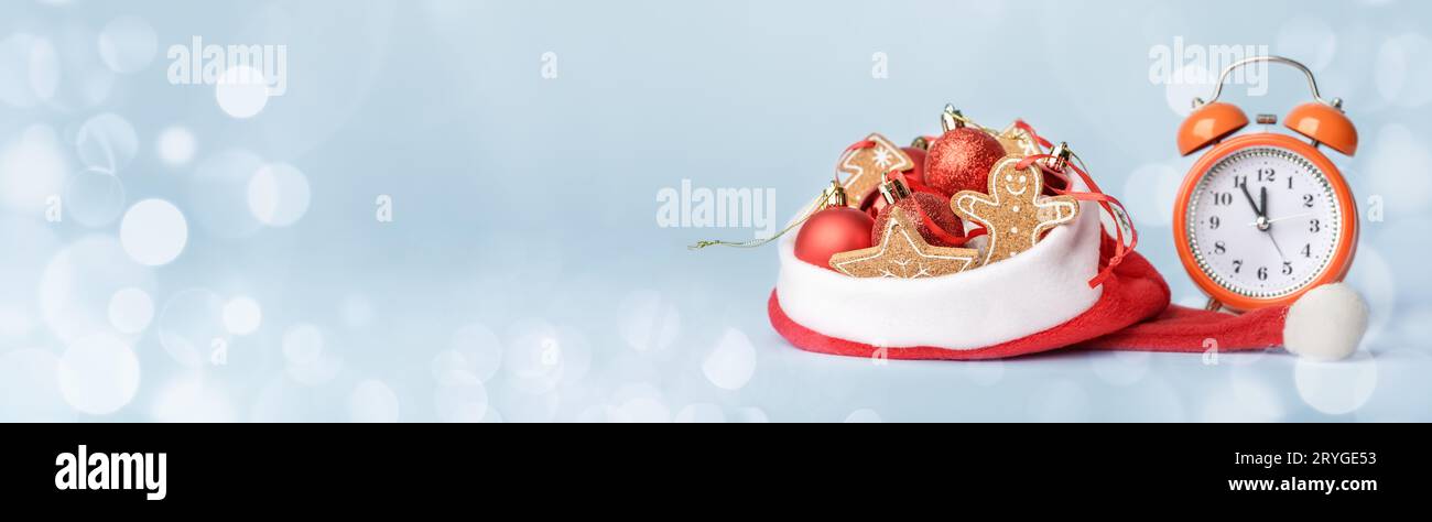 Conceptual photo of meeting the new year, alarm clock and Christmas tree decorations in Santas hat Stock Photo