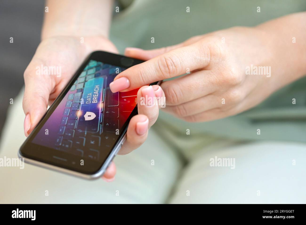 Mobile phone in female hands with screen showing compromised virus infected device. Cyber attack. Stock Photo