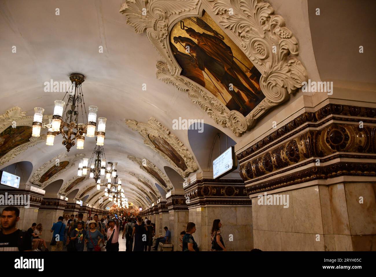 Paintings, stucco, and chandeliers on the ceiling of a subway station in Moscow, Russia Stock Photo