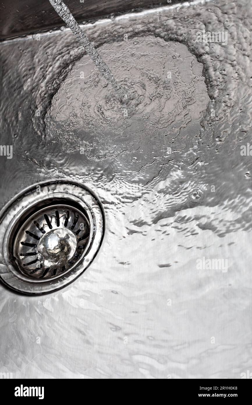 Water drains down a stainless steel sink Stock Photo Alamy