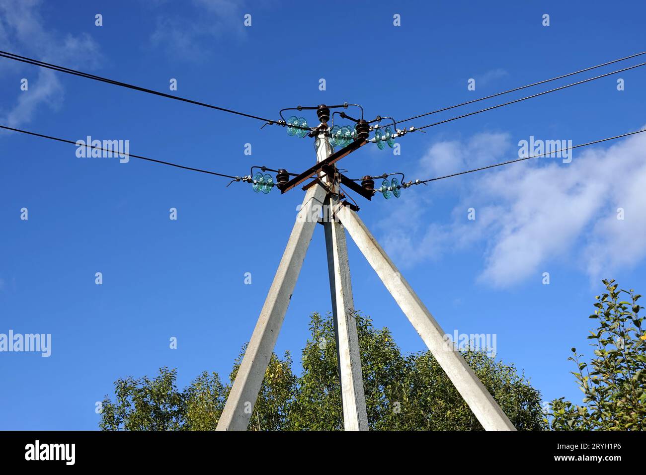 Top of pylon of power supply line with wires and insulators in rural