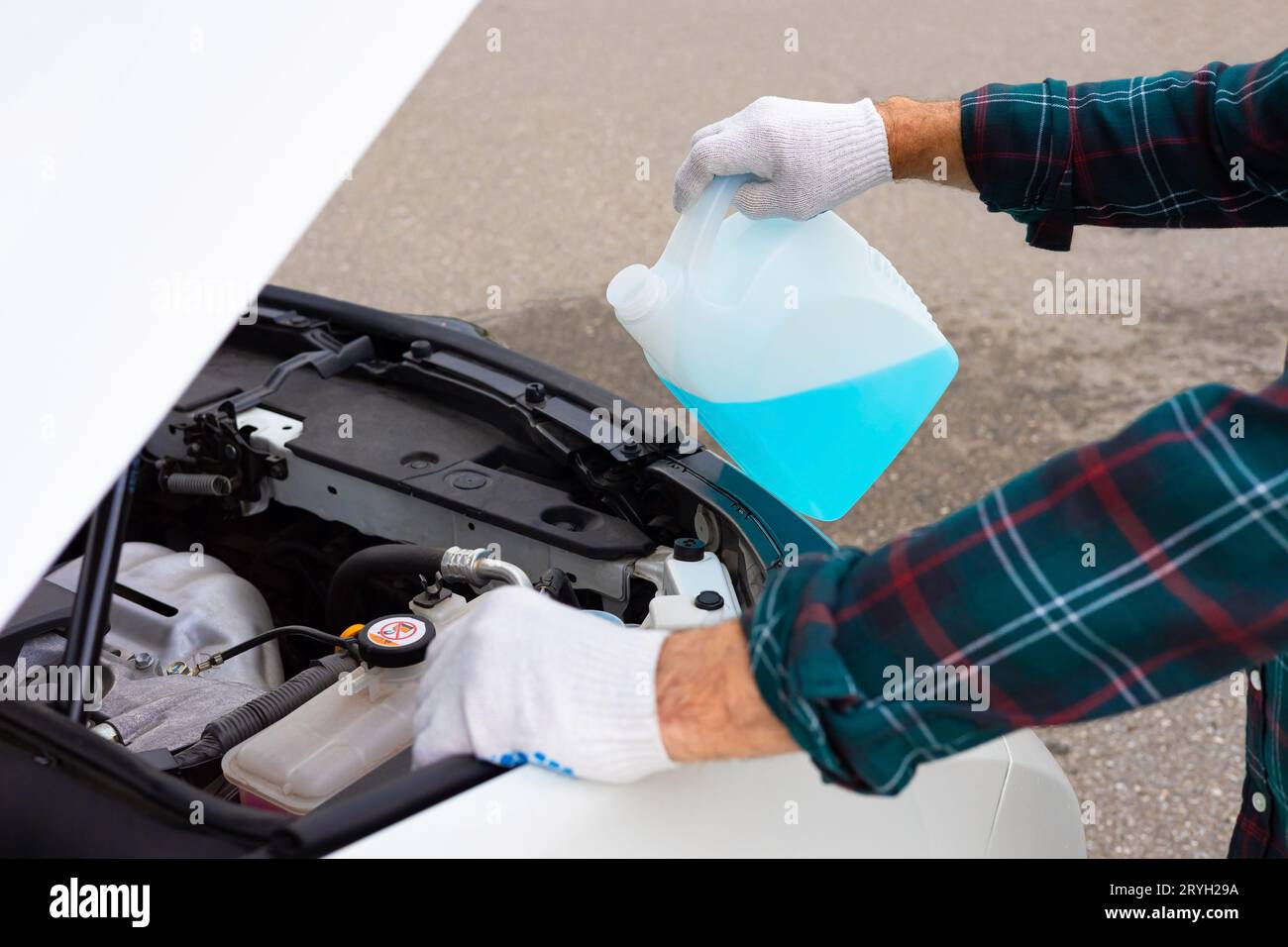 pour antifreeze. the driver pours fluid into the washer reservoir