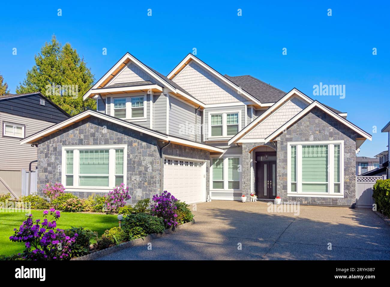 A perfect neighbourhood. Brand new luxury family house on bright winter day Stock Photo
