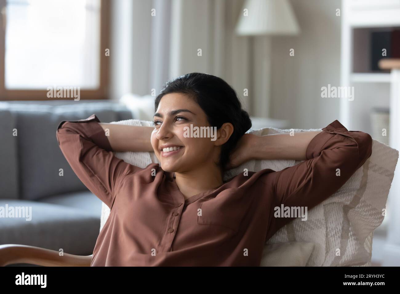 Close up smiling dreamy Indian woman relaxing in chair Stock Photo - Alamy
