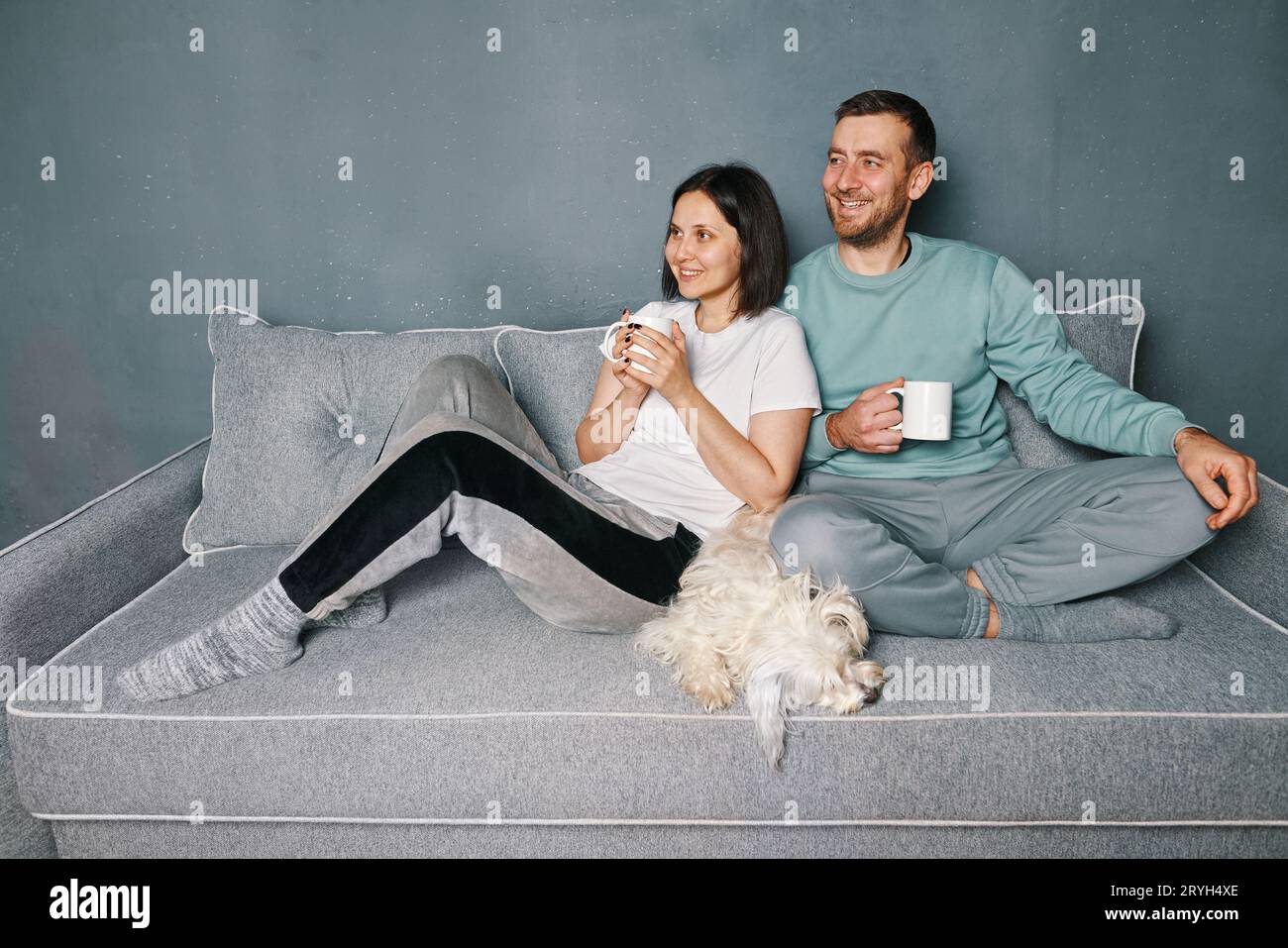 Happy smiling couple drinking coffee relaxing on couch Stock Photo