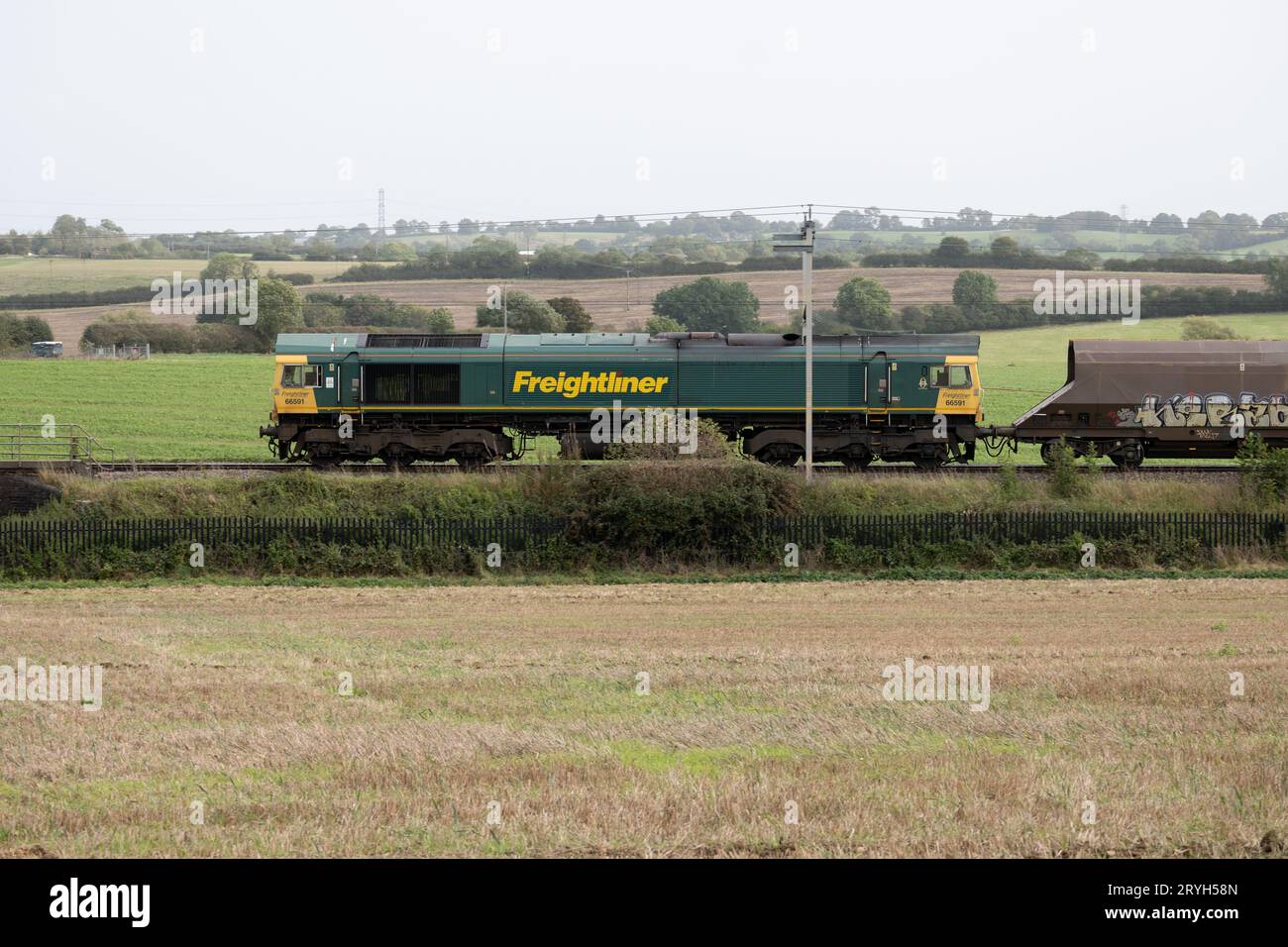 Freightliner class 66 diesel locomotive pulling a freight train on the West Coast Main Line, Northamptonshire, England, UK Stock Photo