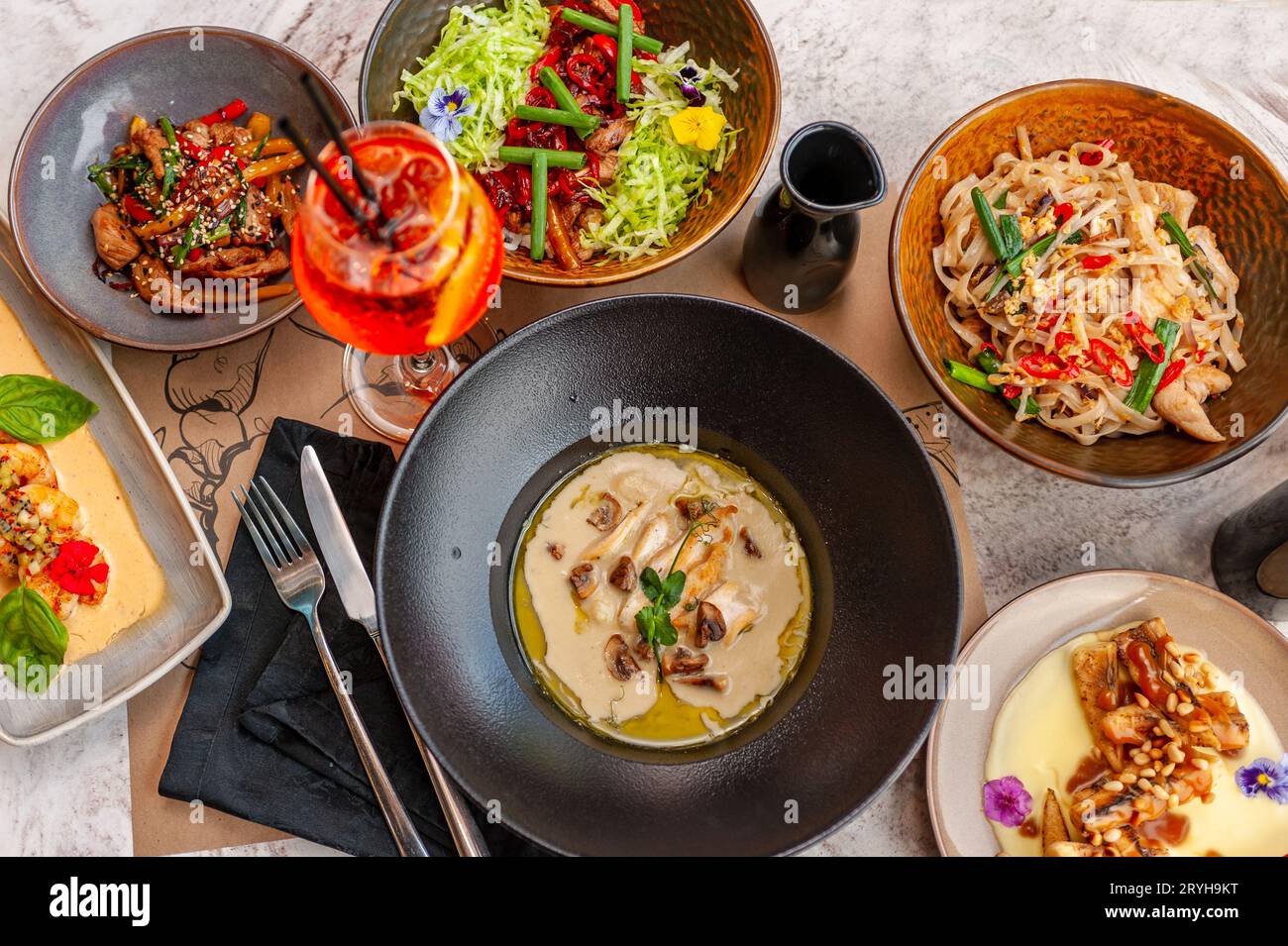 A set of Thai cuisine dishes on a table in a restaurant with a cocktail. View from above. High quality photo Stock Photo