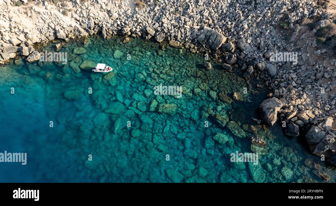 Drone aerial seascape with luxury yacht moored on the coast. Blue water Summer vacations in the sea. Stock Photo