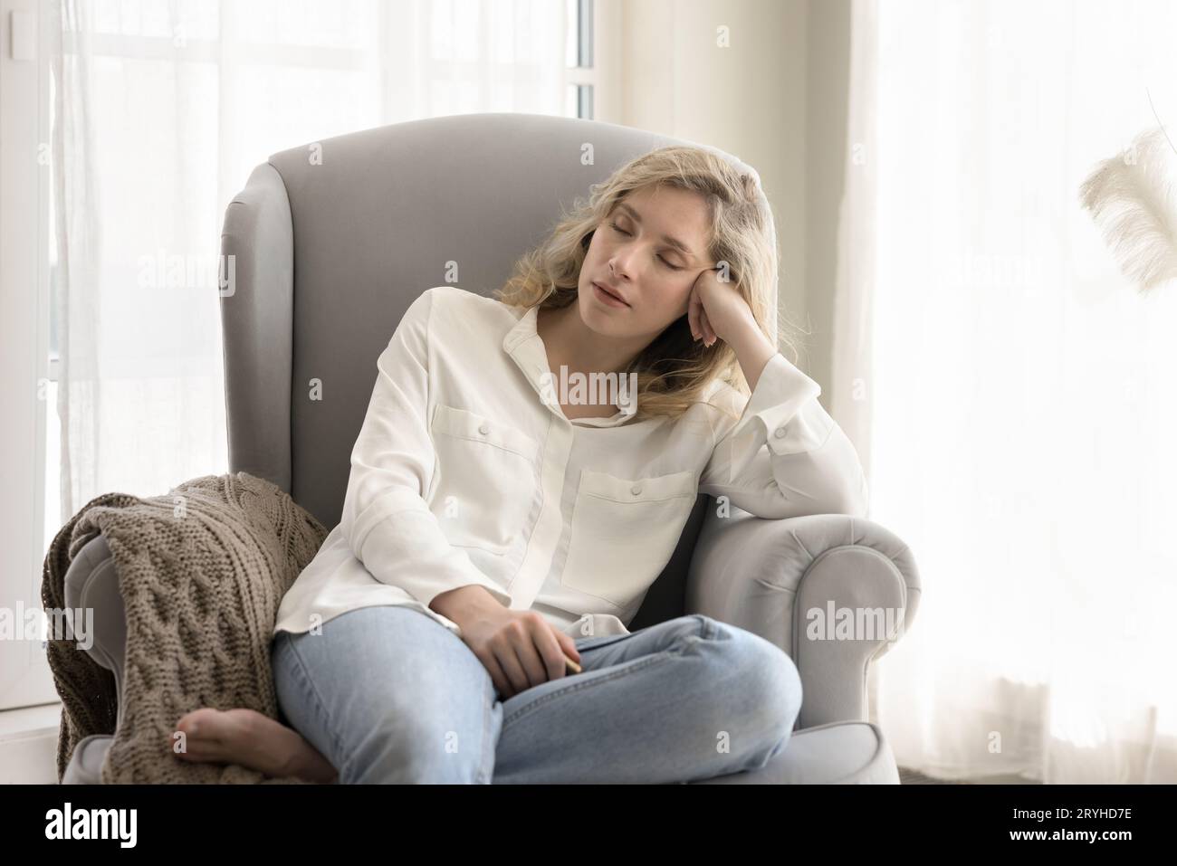 Relaxed calm woman have daytime rest seated on armchair Stock Photo