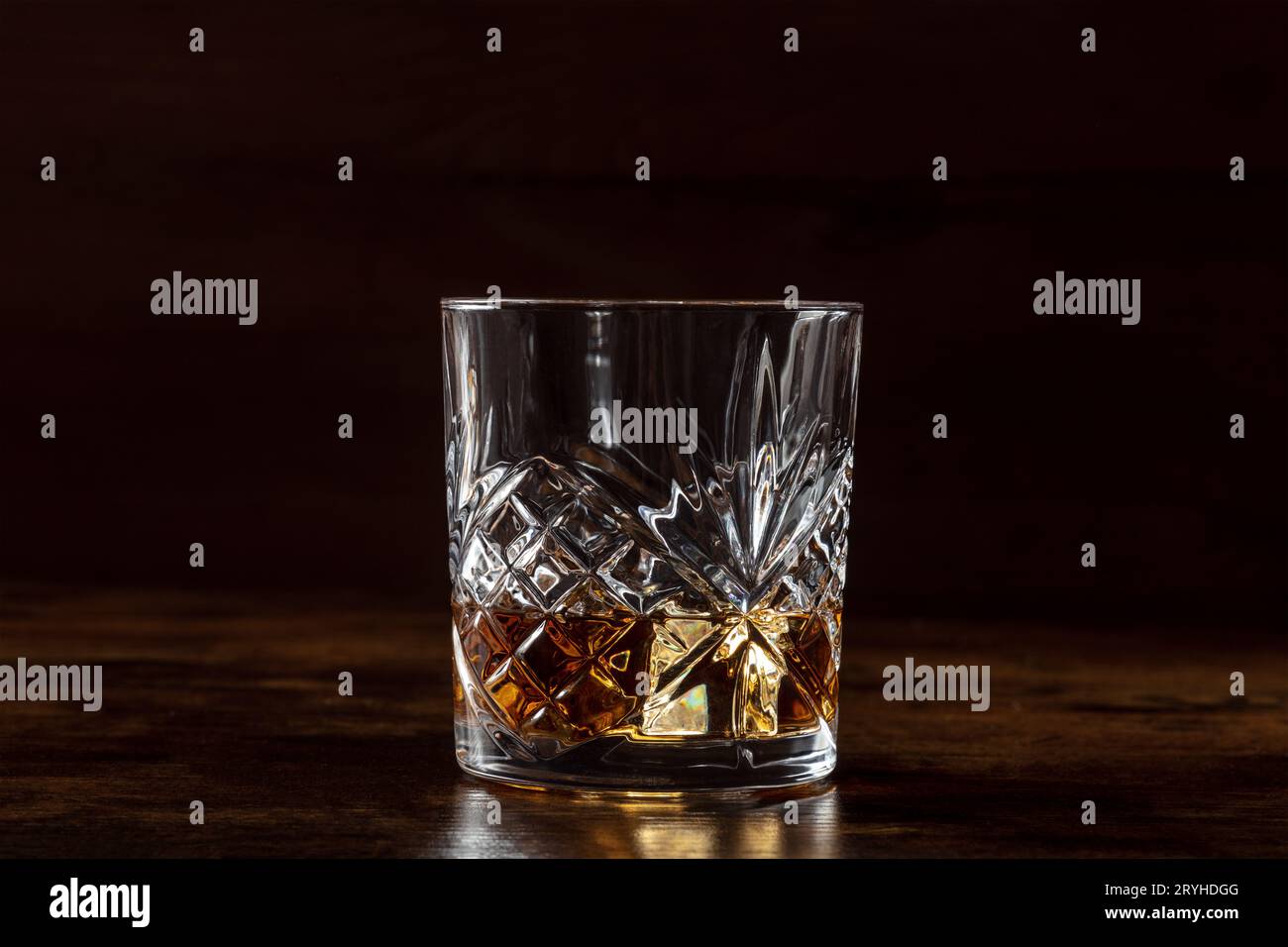 Whiskey in a glass with ice. Bourbon whisky on rocks on a dark background Stock Photo